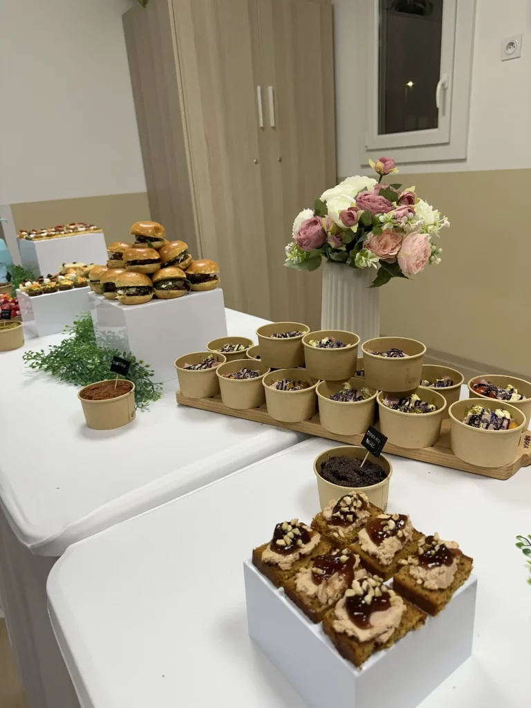 Buffet réalisé par Maison Mélia avec mini burgers, desserts en verrines et bouchées sucrées présenté sur table lors d’un événement.