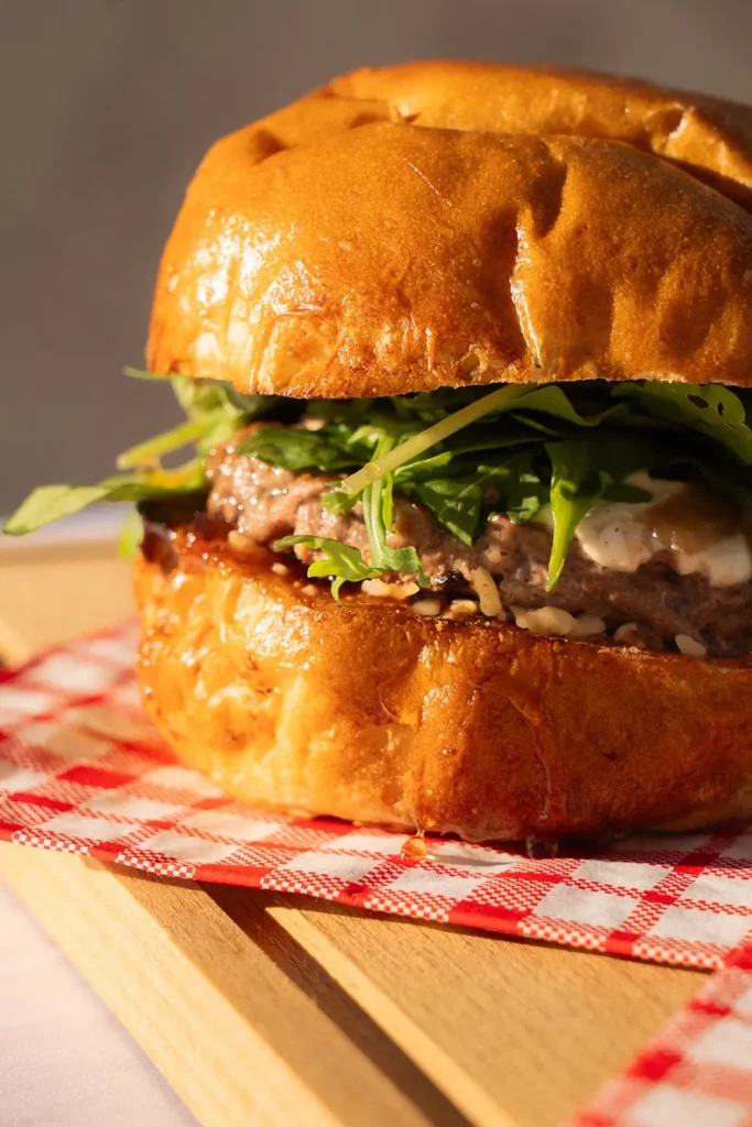 Burger réalisé par Maison Mélia composé d'un steak, de salade et de sauce.