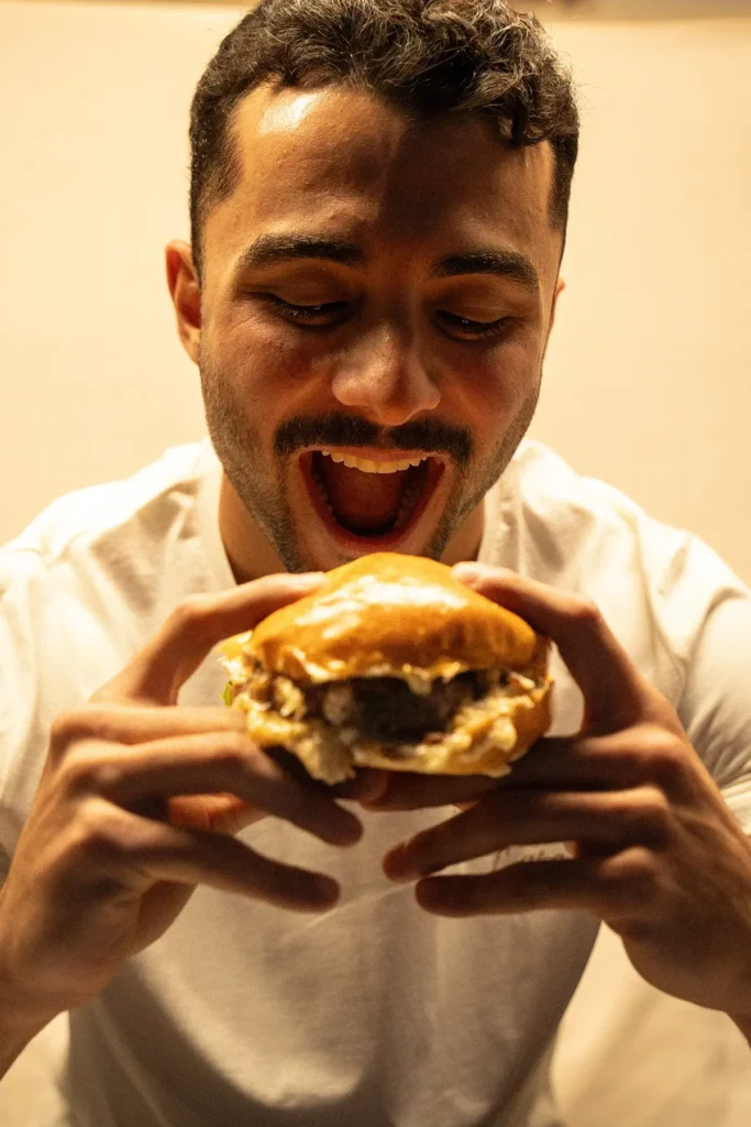 Homme sur le point de manger un burger.