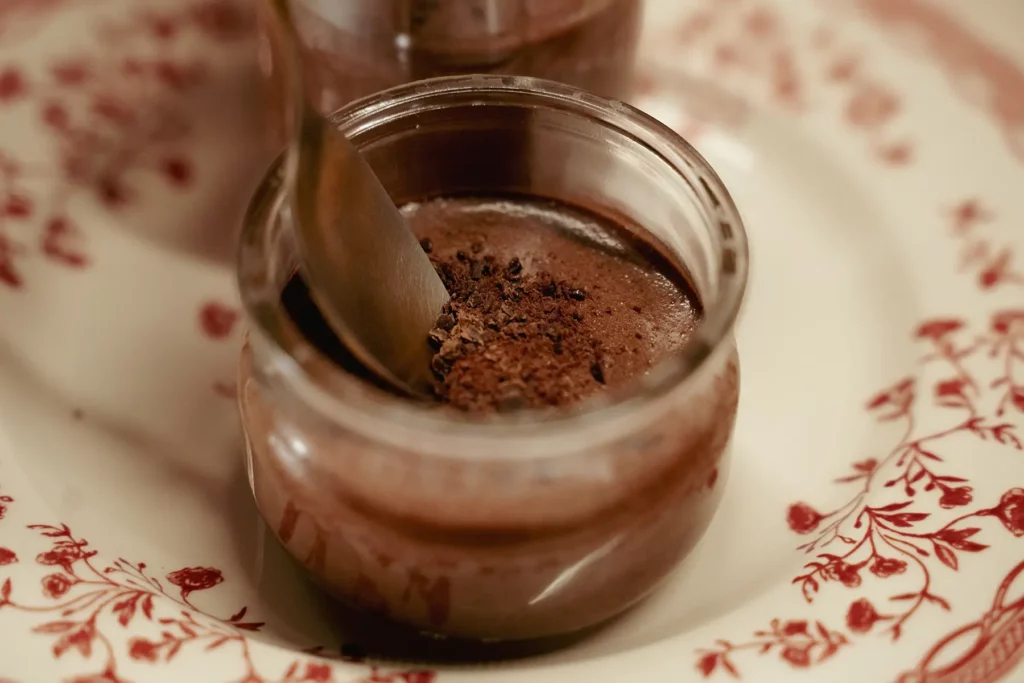 Mousse au chocolat avec une cuillère et des copeaux de cacao réalisé par Maison Mélia.